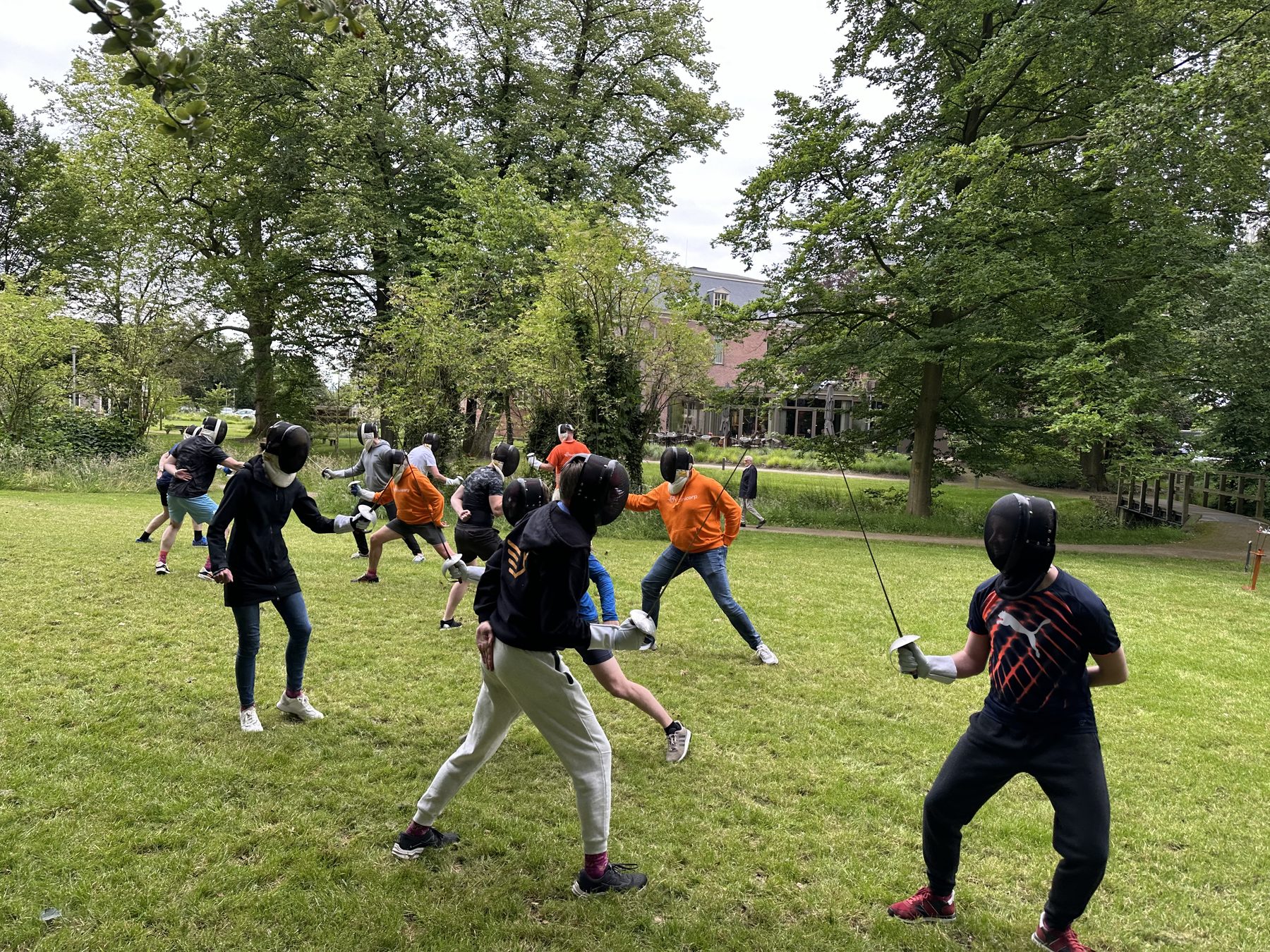 Collega's schermen op een grasveld voor een kasteel.
