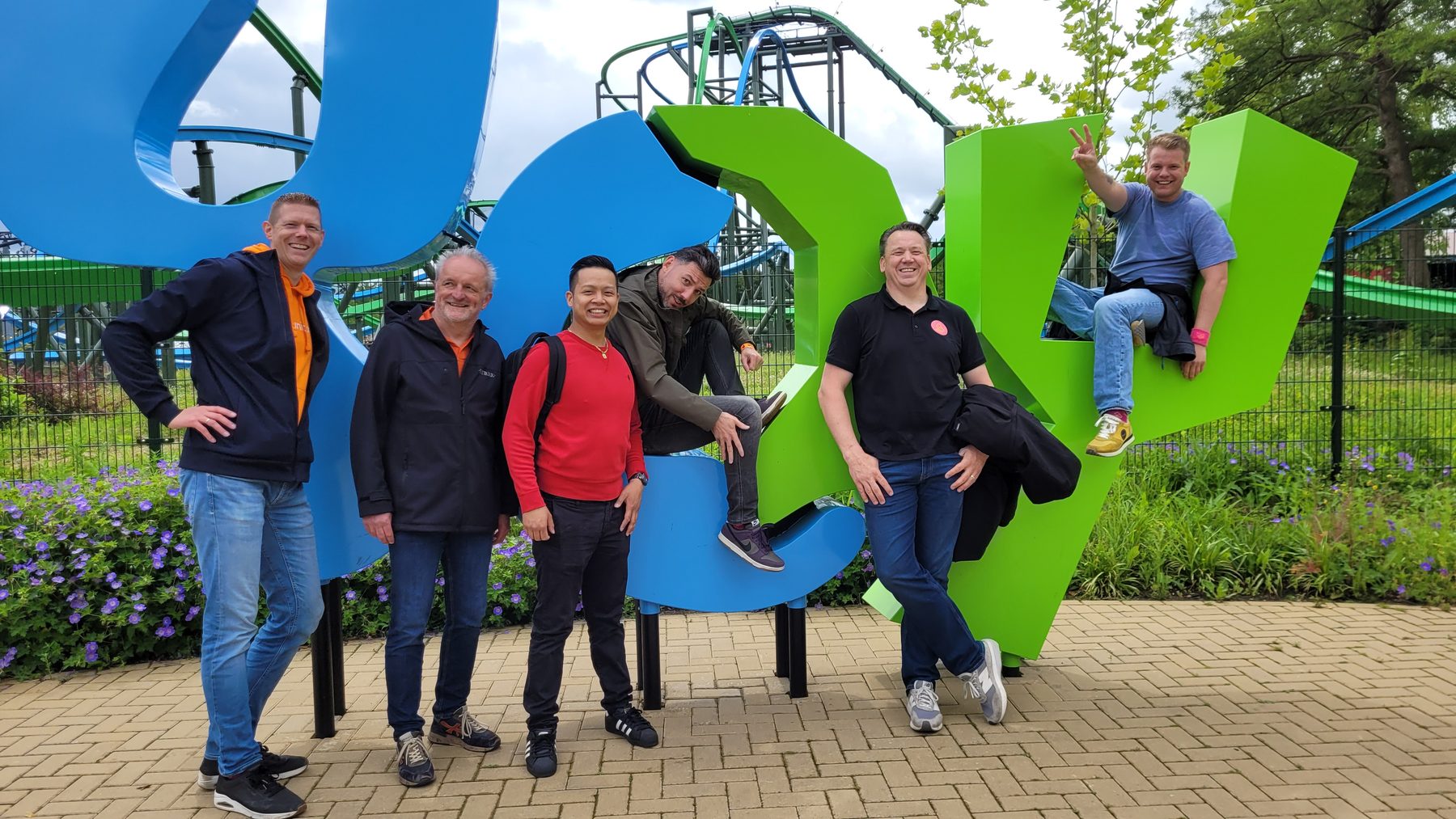 Het team poseert bij de grote blauw-groene letters van Walibi Holland.